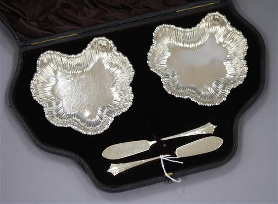 A pair of Victorian silver butter dishes and Onslow handled butter knives, cased, London 1891.